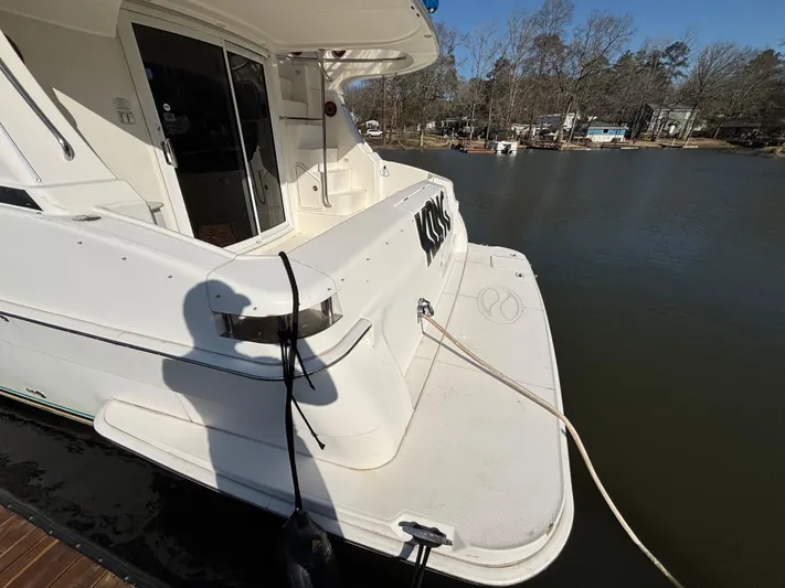 Kong Yacht Photos Pics 2005 Silverton 38 Sport Bridge yacht docked by a calm lake.