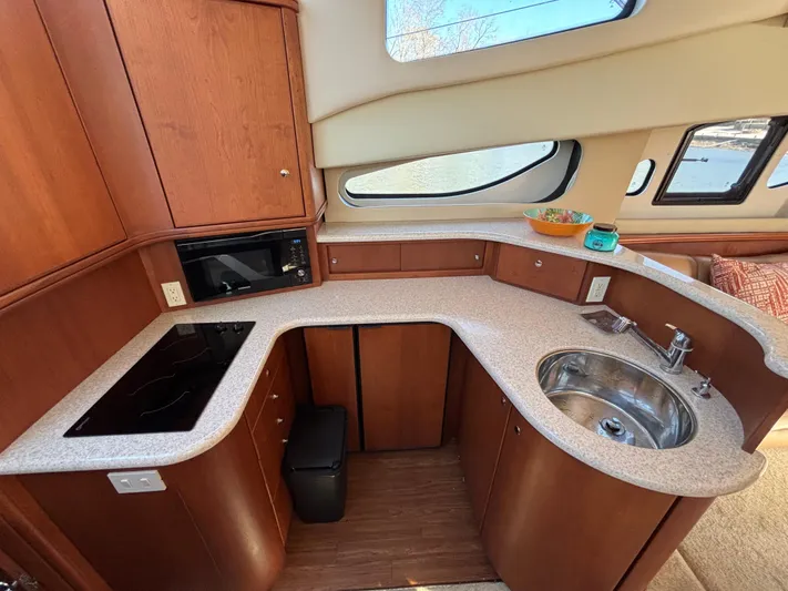 Kong Yacht Photos Pics 2005 Silverton 38 Sport Bridge yacht kitchen with wood cabinetry, sink, and appliances.