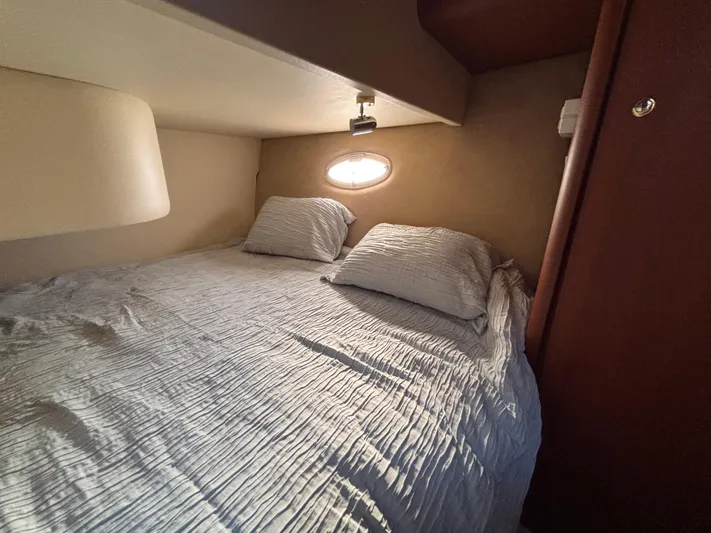 Kong Yacht Photos Pics Cozy cabin bedroom in 2005 Silverton 38 Sport Bridge yacht with soft lighting.