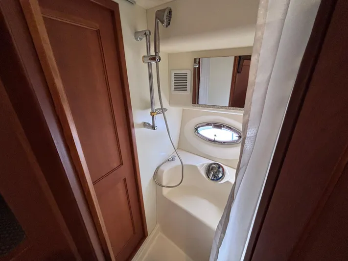 Kong Yacht Photos Pics Shower area in 2005 Silverton 38 Sport Bridge yacht with wooden door and porthole window.