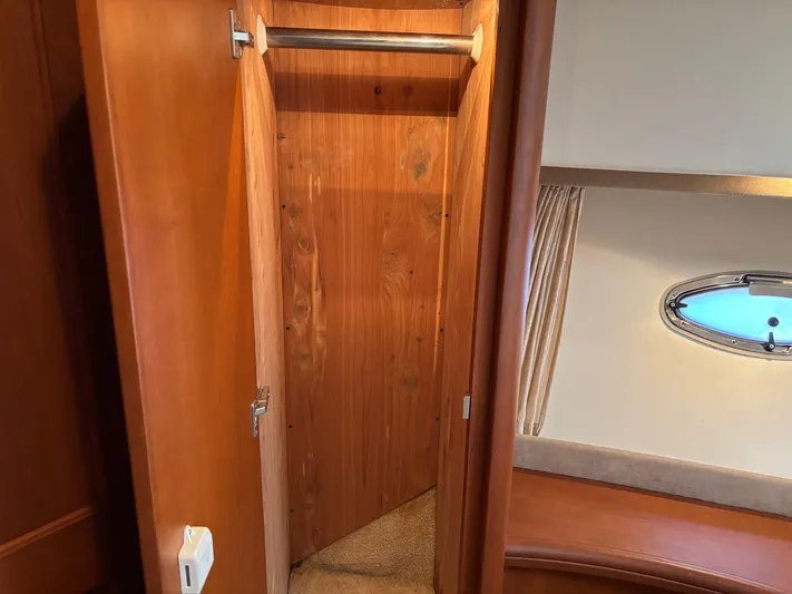 Kong Yacht Photos Pics 2005 Silverton 38 Sport Bridge interior closet with wooden finish and porthole window.