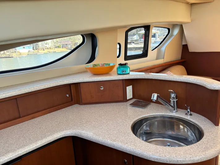 Kong Yacht Photos Pics 2005 Silverton 38 Sport Bridge yacht interior with kitchenette, featuring sink and windows.