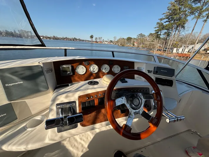 Kong Yacht Photos Pics 2005 Silverton 38 Sport Bridge helm with Raymarine electronics, overlooking serene lake view.