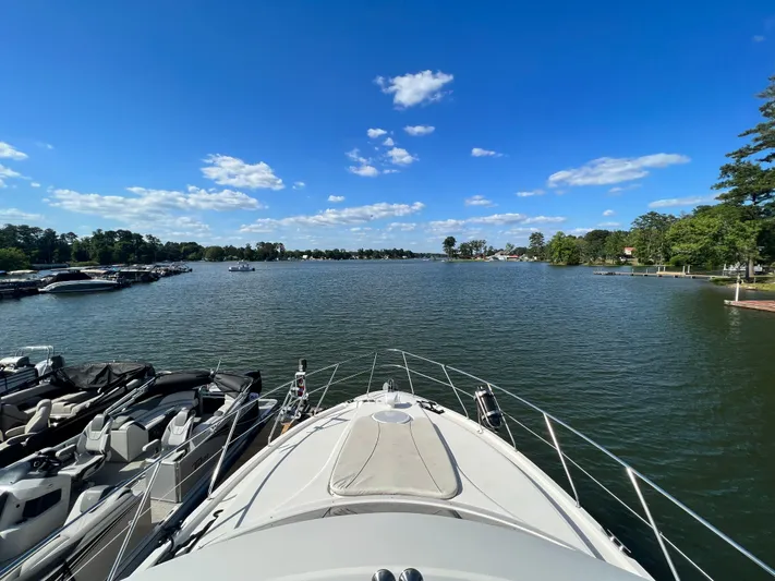 Kong Yacht Photos Pics 2005 Silverton 38 Sport Bridge on a serene lake under a clear blue sky.