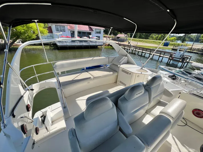Kong Yacht Photos Pics 2005 Silverton 38 Sport Bridge yacht interior with seating and helm, docked near waterfront.