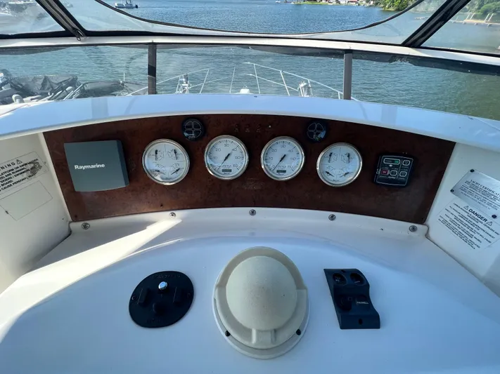 Kong Yacht Photos Pics 2005 Silverton 38 Sport Bridge helm with gauges and Raymarine equipment, overlooking water.