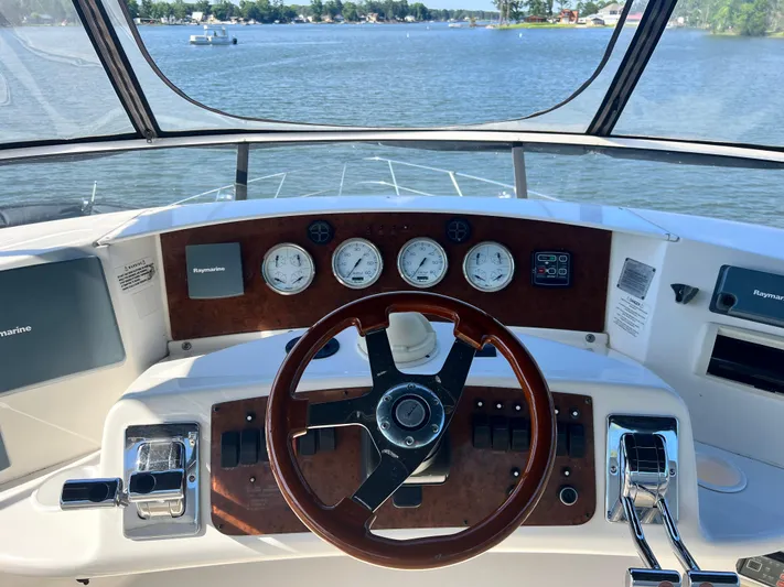 Kong Yacht Photos Pics 2005 Silverton 38 Sport Bridge helm with Raymarine electronics, overlooking serene water view.