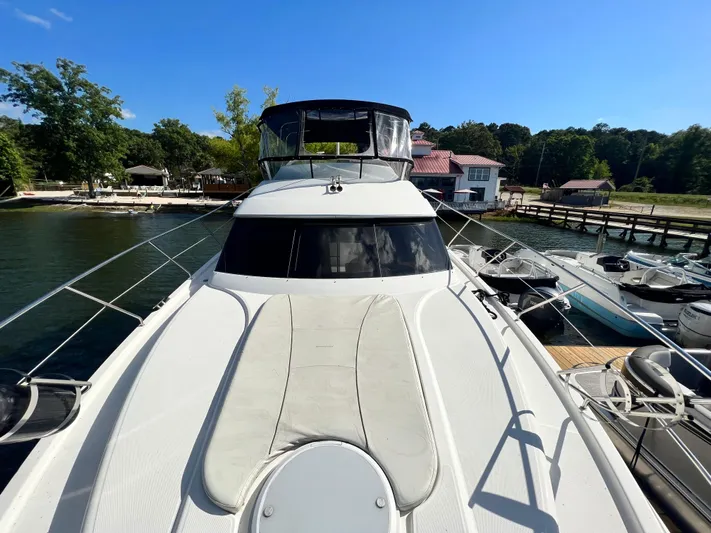 Kong Yacht Photos Pics 2005 Silverton 38 Sport Bridge yacht docked at a marina under clear blue skies.