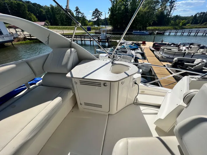 Kong Yacht Photos Pics 2005 Silverton 38 Sport Bridge yacht interior with seating and sink, docked by a scenic marina.
