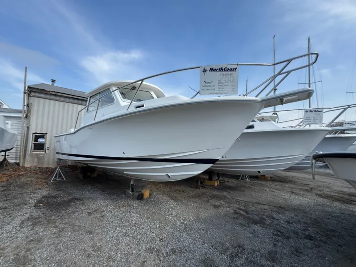  Yacht Photos Pics 2025 NorthCoast 255 HT boat on display, white hull, parked on gravel lot.