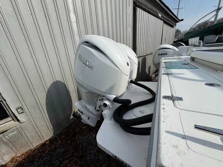  Yacht Photos Pics 2025 NorthCoast 255 HT boat with Yamaha outboard motor, docked near a metal building.