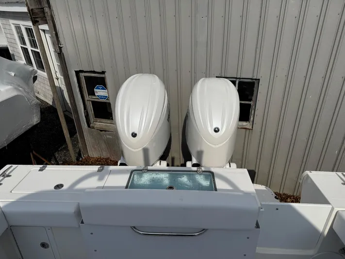  Yacht Photos Pics 2025 NorthCoast 255 HT boat with dual outboard engines, docked near a building.