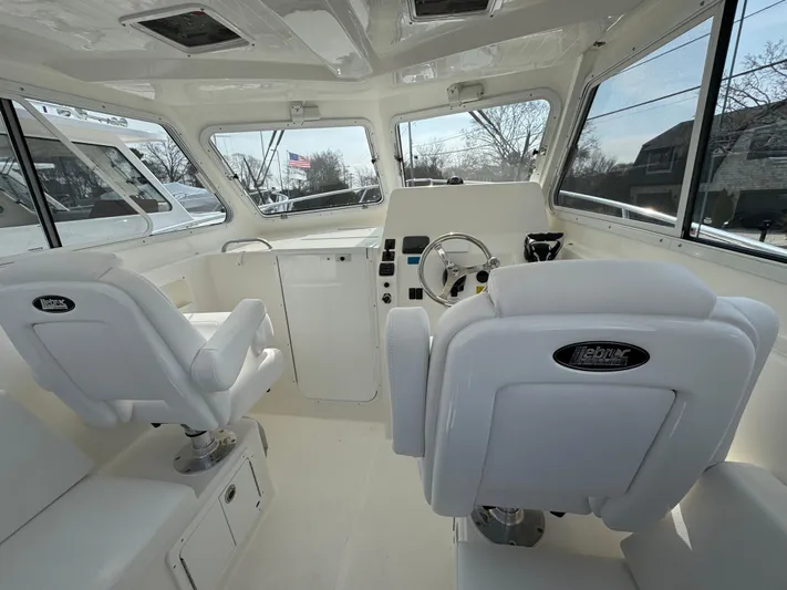  Yacht Photos Pics Interior of 2025 NorthCoast 255 HT boat with white seating and modern dashboard.