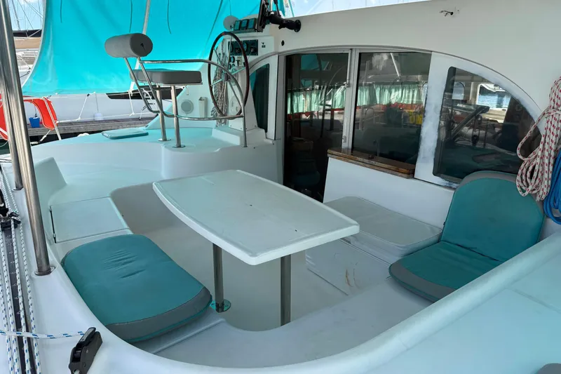  Yacht Photos Pics 2003 Lagoon 380 catamaran cockpit with seating, table, and helm station.