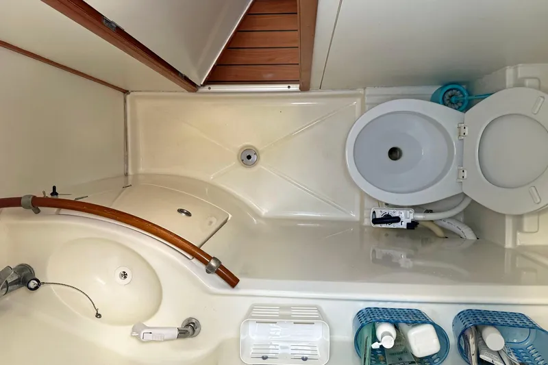  Yacht Photos Pics Bathroom of 2003 Lagoon 380 catamaran with toilet, sink, and storage baskets.