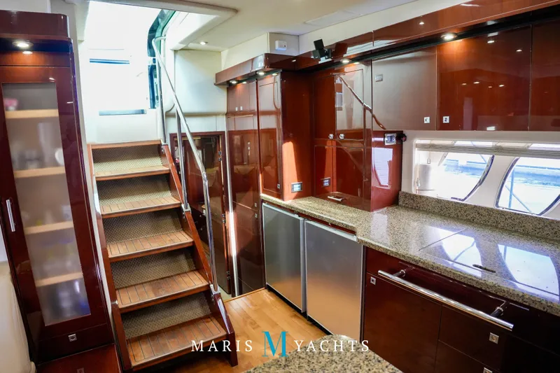 Man O War Yacht Photos Pics Luxurious interior of 2009 Sea Ray 55 Sundancer yacht with modern kitchen and wooden stairs.