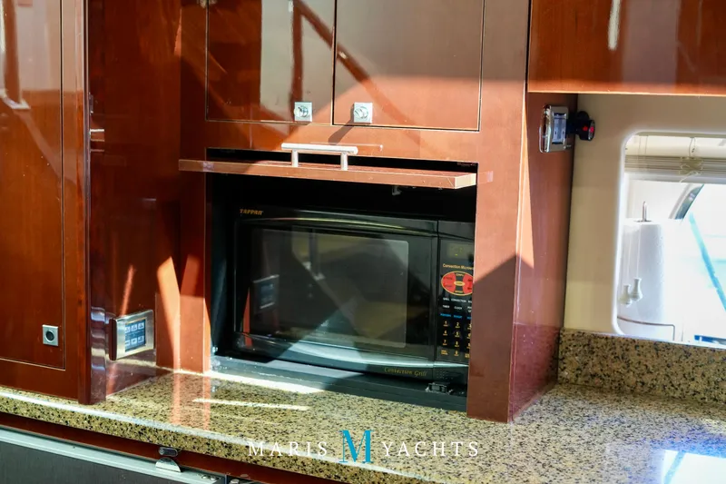 Man O War Yacht Photos Pics Luxury yacht kitchen with microwave, granite countertop, and wooden cabinetry on 2009 Sea Ray 55 Sundancer.