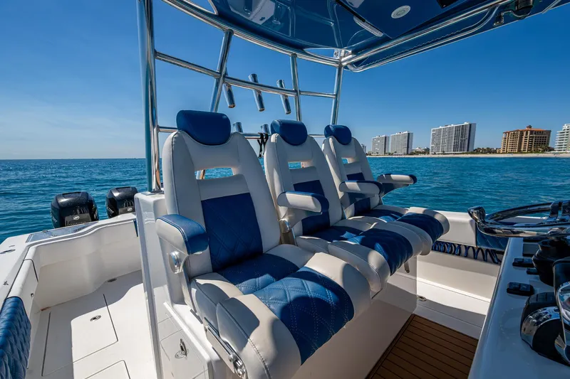  Yacht Photos Pics 2020 Front Runner 39 boat interior with blue and white seating, ocean view, and city skyline.