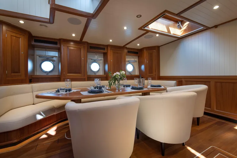 Melody Yacht Photos Pics Luxurious dining area inside 2022 Ridas Custom Yacht, featuring elegant wood paneling and plush seating.
