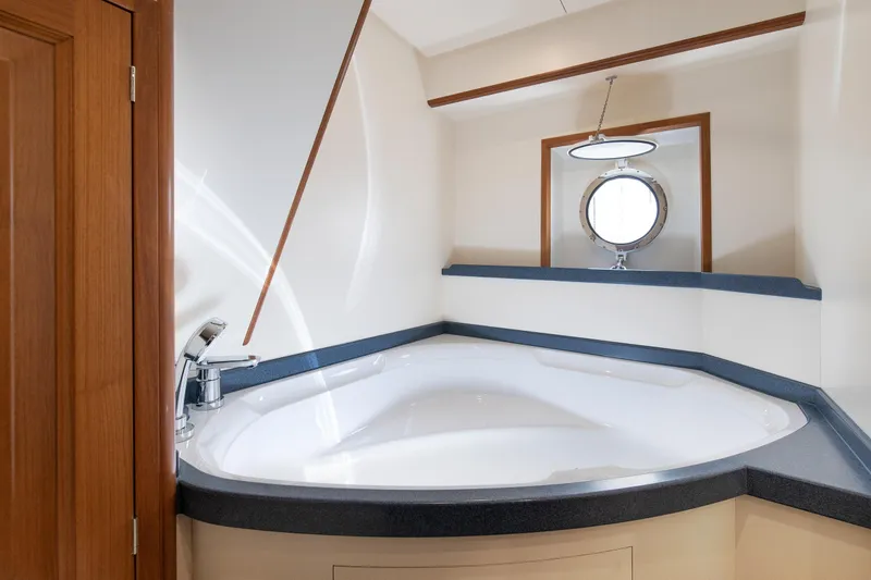 Melody Yacht Photos Pics Luxurious bathroom in 2022 Ridas Custom Yacht with modern fixtures and porthole window.
