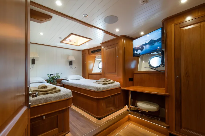 Melody Yacht Photos Pics Luxurious 2022 Ridas Custom Yacht cabin with twin beds, TV, and elegant wood finish.
