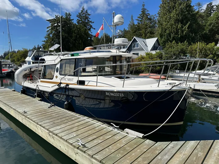  Yacht Photos Pics 2023 Ranger Tugs R-29 S docked at marina, surrounded by trees.