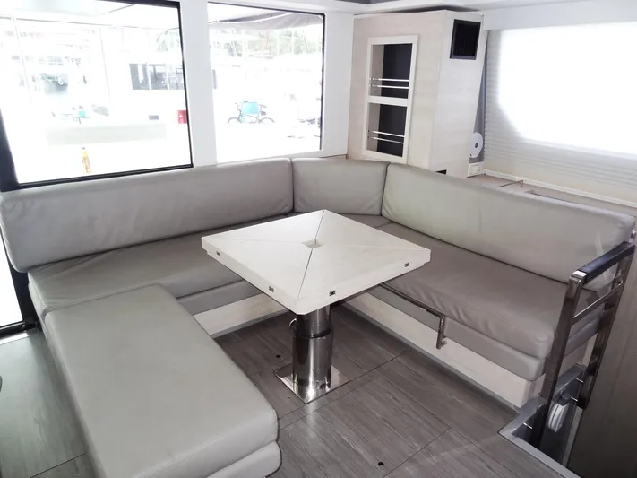 Aquaholic Yacht Photos Pics Modern interior of 2019 Leopard 50 yacht with L-shaped seating and table.