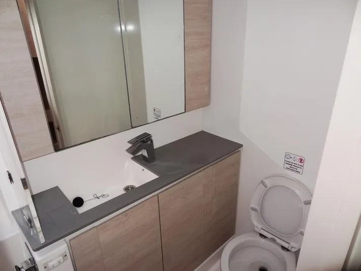 Aquaholic Yacht Photos Pics Modern bathroom in a 2019 Leopard 50 yacht with sink, mirror, and toilet.
