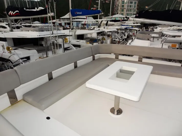 Aquaholic Yacht Photos Pics Leopard 50 yacht 2019 model, spacious outdoor seating area with table, docked among other yachts.