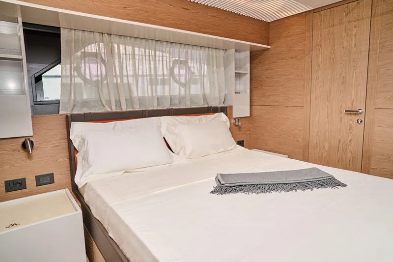  Yacht Photos Pics Luxurious bedroom interior of 2023 Ferretti Yachts 920 with elegant wood finishes.