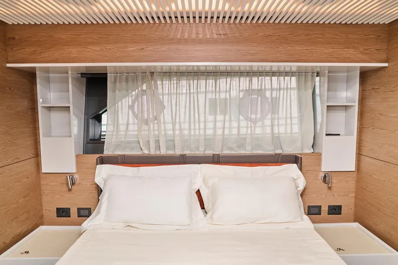  Yacht Photos Pics Luxurious bedroom interior of 2023 Ferretti Yachts 920 with elegant wood paneling.