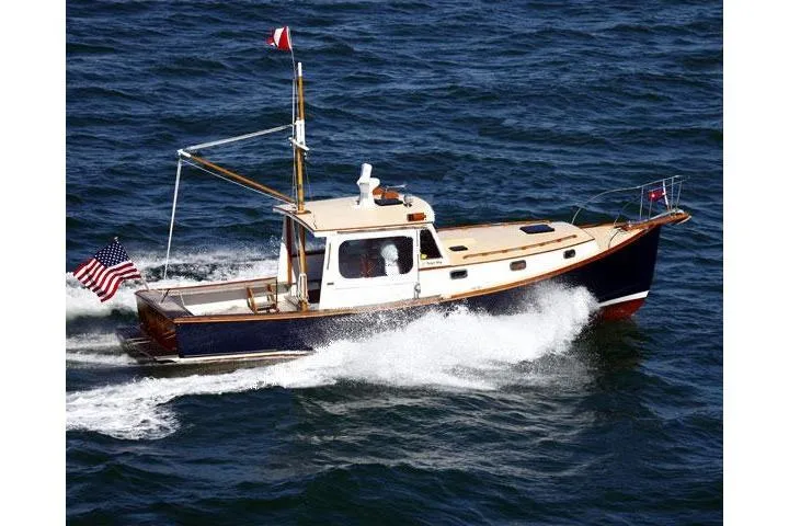 Bugle Boy Yacht Photos Pics 1994 John Williams Stanley 36 boat cruising on open water, displaying American flag.