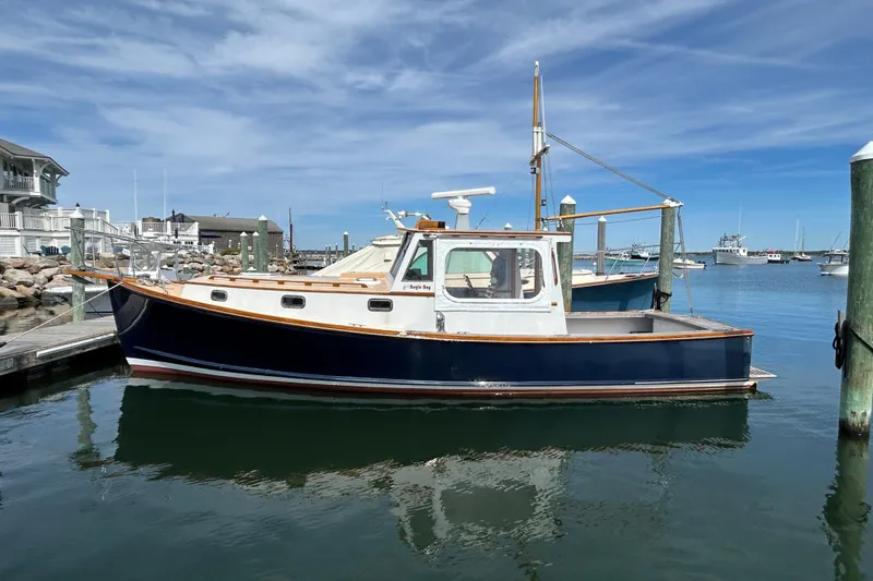 Bugle Boy Yacht Photos Pics 1994 John Williams Stanley 36 boat docked in a serene marina under a clear blue sky.