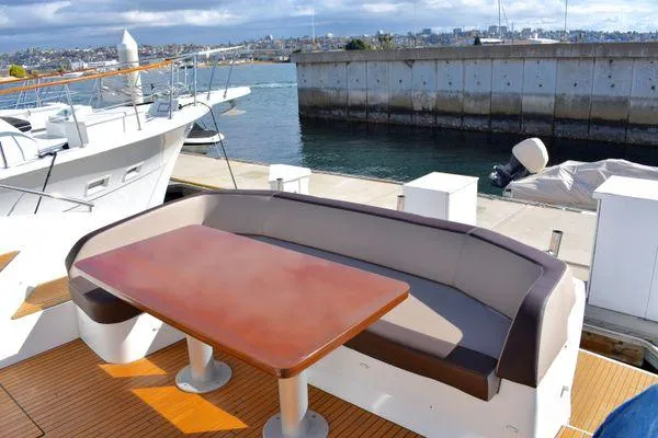 Be Water My Friend Yacht Photos Pics 2016 Beneteau GT49 yacht deck with seating and table, docked at marina.