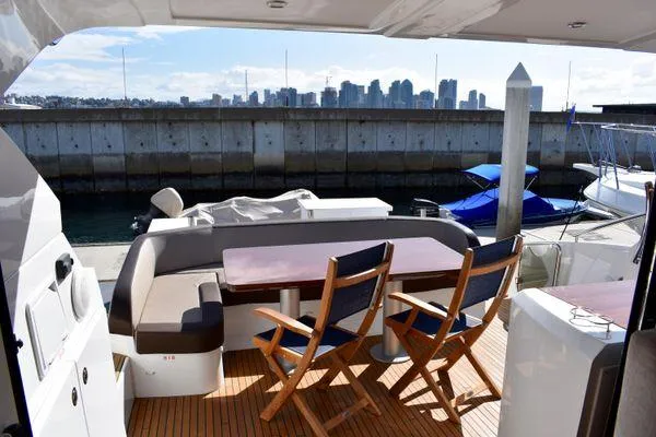 Be Water My Friend Yacht Photos Pics 2016 Beneteau GT49 yacht deck with seating, city skyline in background.