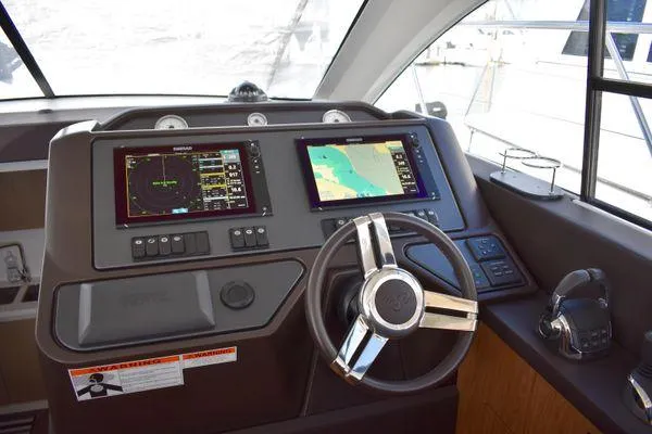 Be Water My Friend Yacht Photos Pics Helm of 2016 Beneteau GT49 yacht with navigation screens and steering wheel.