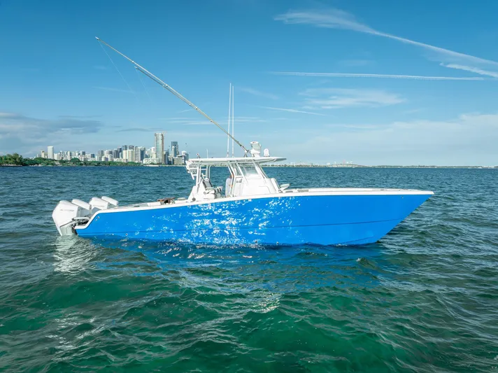  Yacht Photos Pics Blue Freeman 37 boat on water, city skyline in background, clear sky, 2021 model.