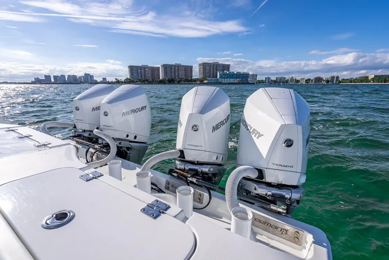  Yacht Photos Pics Triple Mercury outboard engines on a 2021 Freeman 37 boat, ocean backdrop, city skyline.