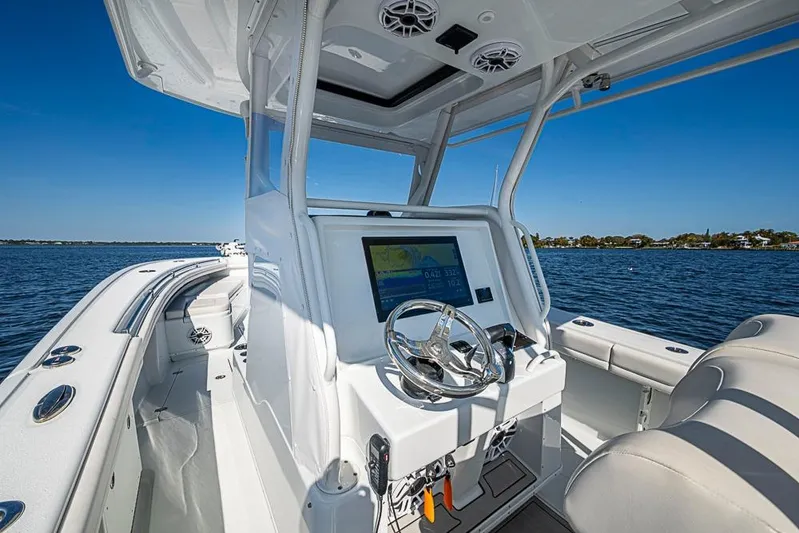  Yacht Photos Pics 2021 Yellowfin 32 Offshore boat interior with steering wheel and navigation system.