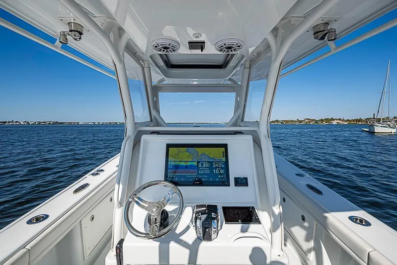  Yacht Photos Pics 2021 Yellowfin 32 Offshore boat dashboard with navigation screen on open water.