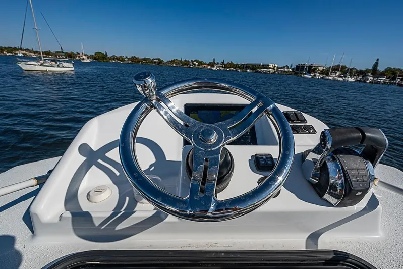  Yacht Photos Pics Steering wheel of 2021 Yellowfin 32 Offshore boat on calm water.