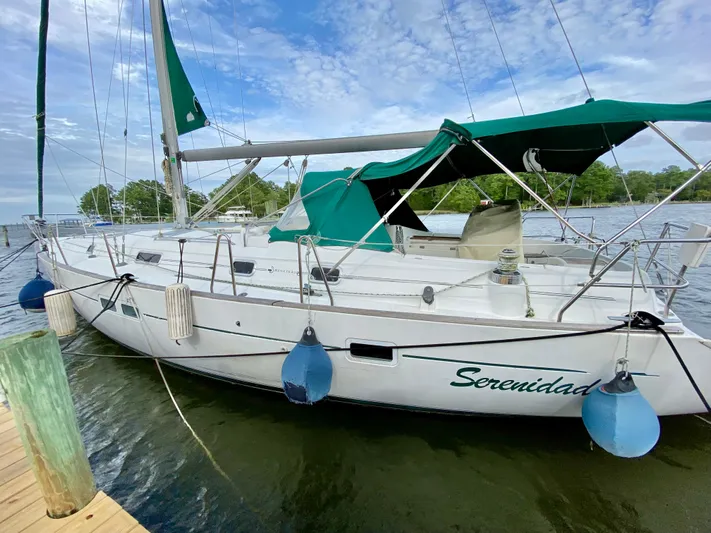 Serenidad Yacht Photos Pics 1999 Beneteau 411 sailboat docked, featuring green canopy and serene waterscape.