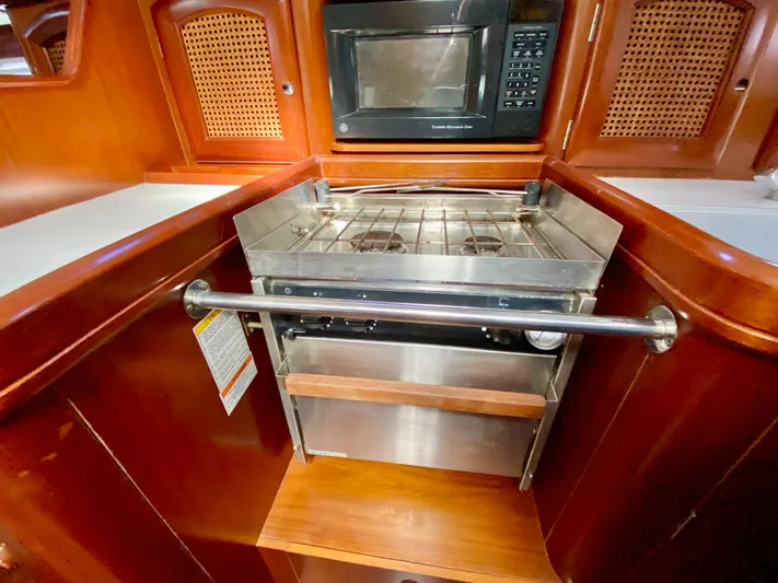 Serenidad Yacht Photos Pics Galley kitchen in 1999 Beneteau 411 yacht with stove and microwave.