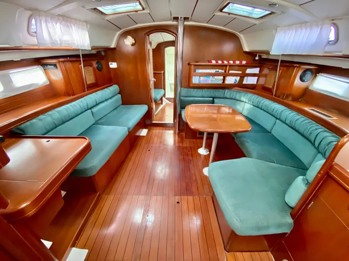 Serenidad Yacht Photos Pics Interior of 1999 Beneteau 411 sailboat with wood finish and green seating.