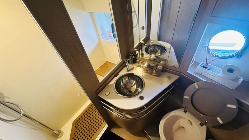  Yacht Photos Pics Luxurious bathroom interior of 2006 Riva 68 Ego yacht with modern fixtures and porthole window.