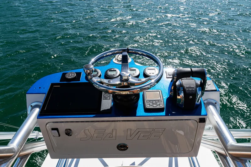  Yacht Photos Pics Helm of 2016 SeaVee 430 boat with steering wheel and controls, overlooking ocean.