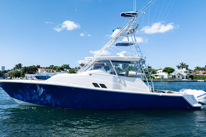  Yacht Photos Pics 2016 SeaVee 430 boat on water, blue hull, clear sky, waterfront homes in background.