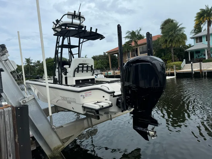  Yacht Photos Pics 2024 Pathfinder 2500 Hybrid boat on lift by waterfront homes.