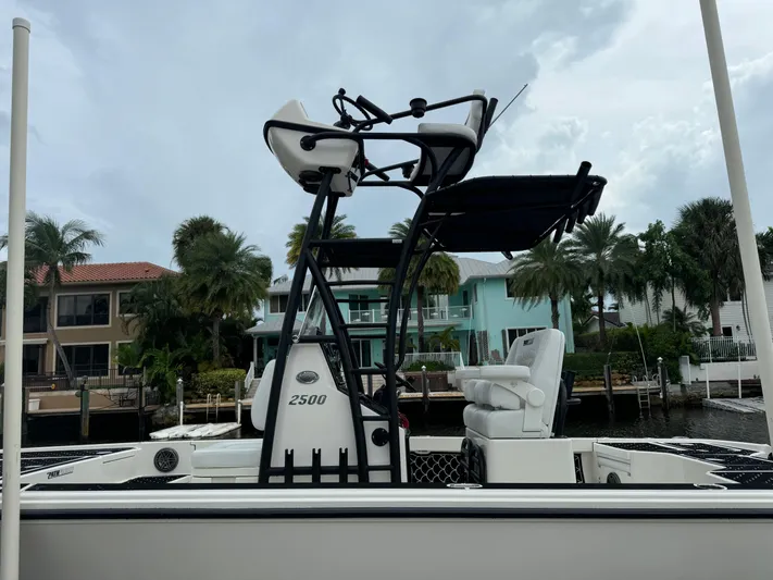  Yacht Photos Pics 2024 Pathfinder 2500 Hybrid boat docked near waterfront homes.