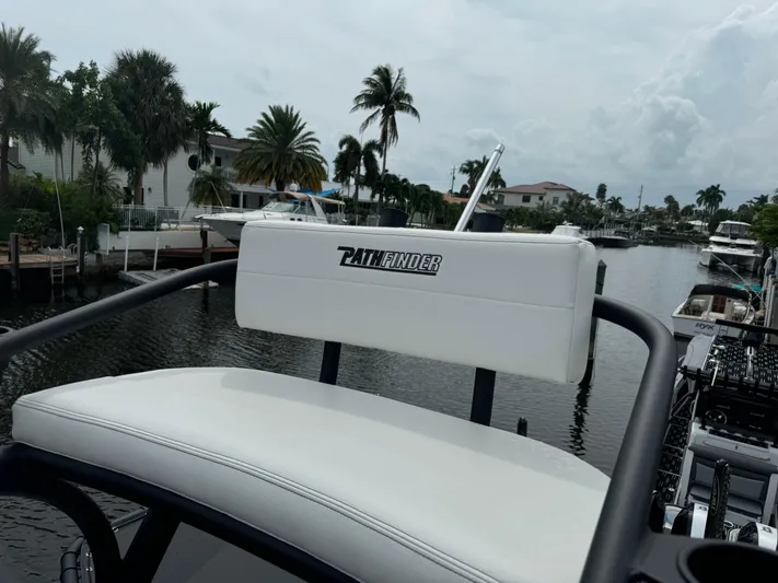  Yacht Photos Pics 2024 Pathfinder 2500 Hybrid boat seat overlooking a scenic canal with palm trees.